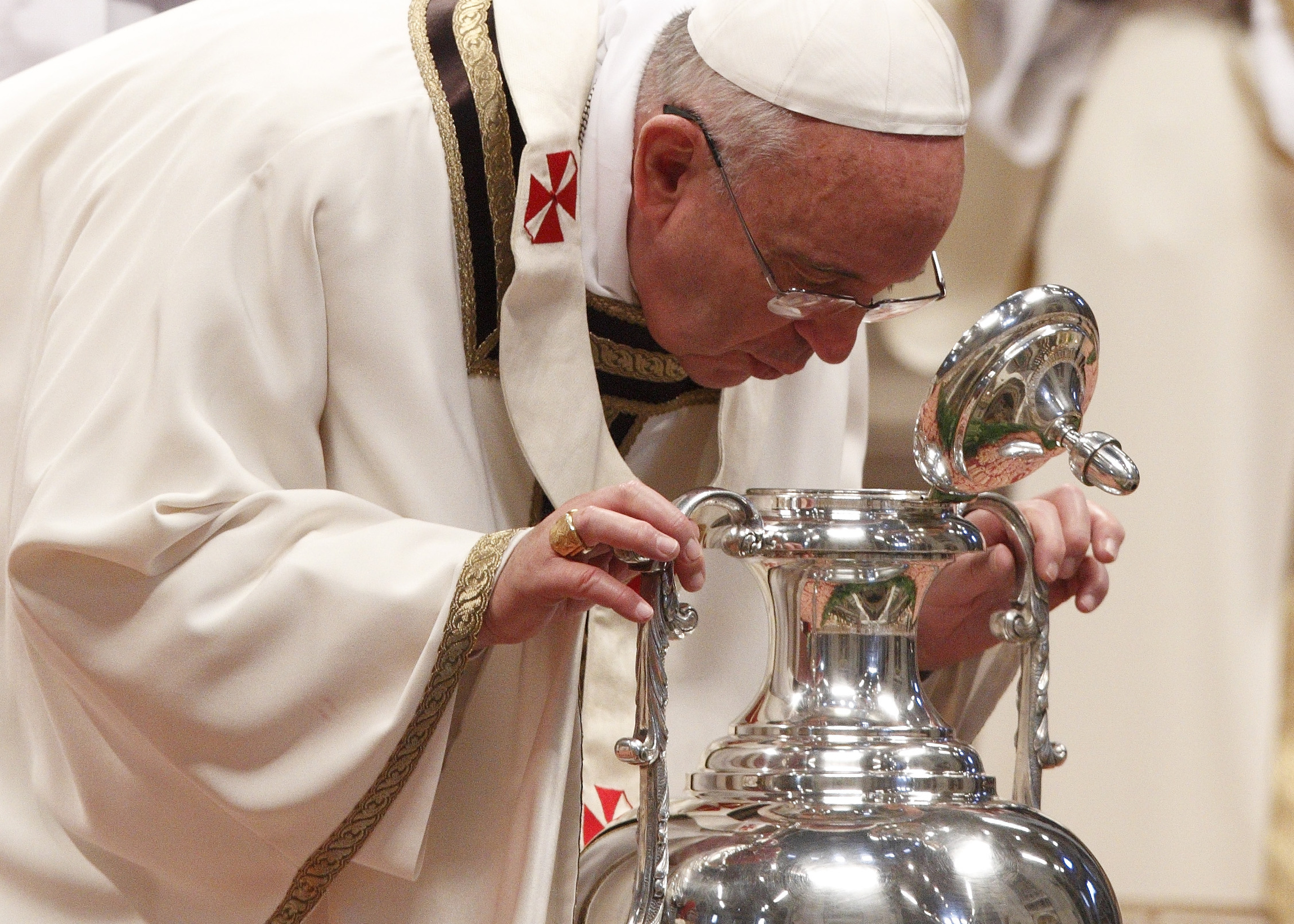 Pope Francis breathes over chrism oil during Holy Thursday chrism Mass